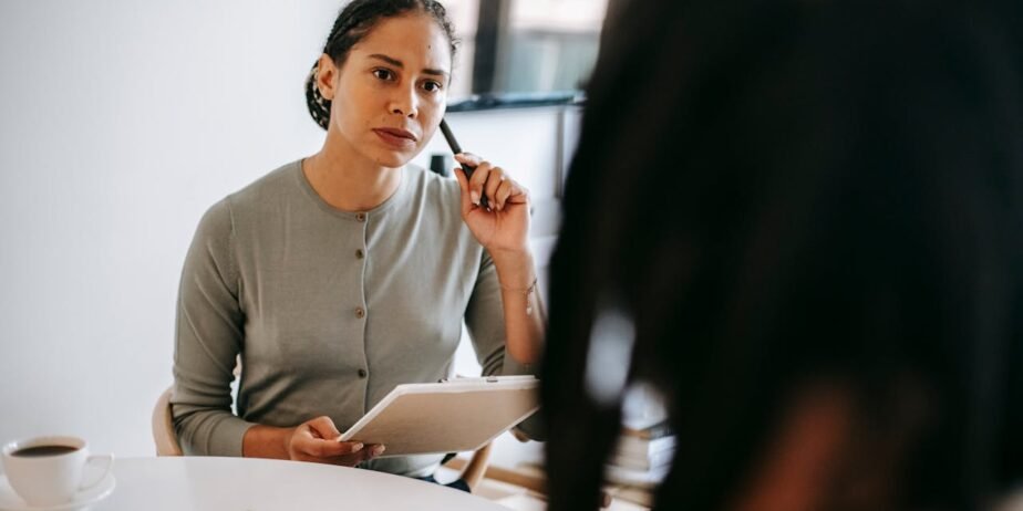 Illustration of a therapist speaking with a client during a counseling session in a private office setting.