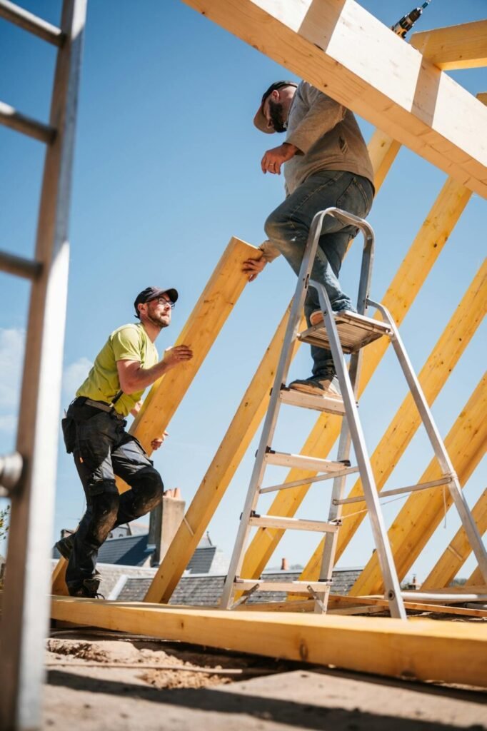 Roofing contractors installing wooden roof framing on a residential home, representing construction and home improvement services in North Atlanta.
