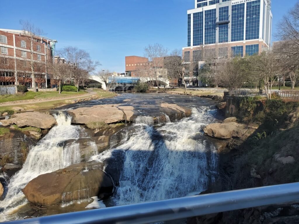 Waterfalls in an urban park with downtown buildings in the background