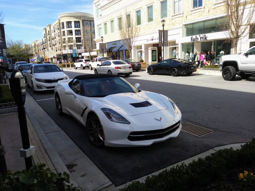 Photo of Avalon in Alpharetta street scene with luxury cars, upscale retail shops, and modern development in North Fulton Georgia