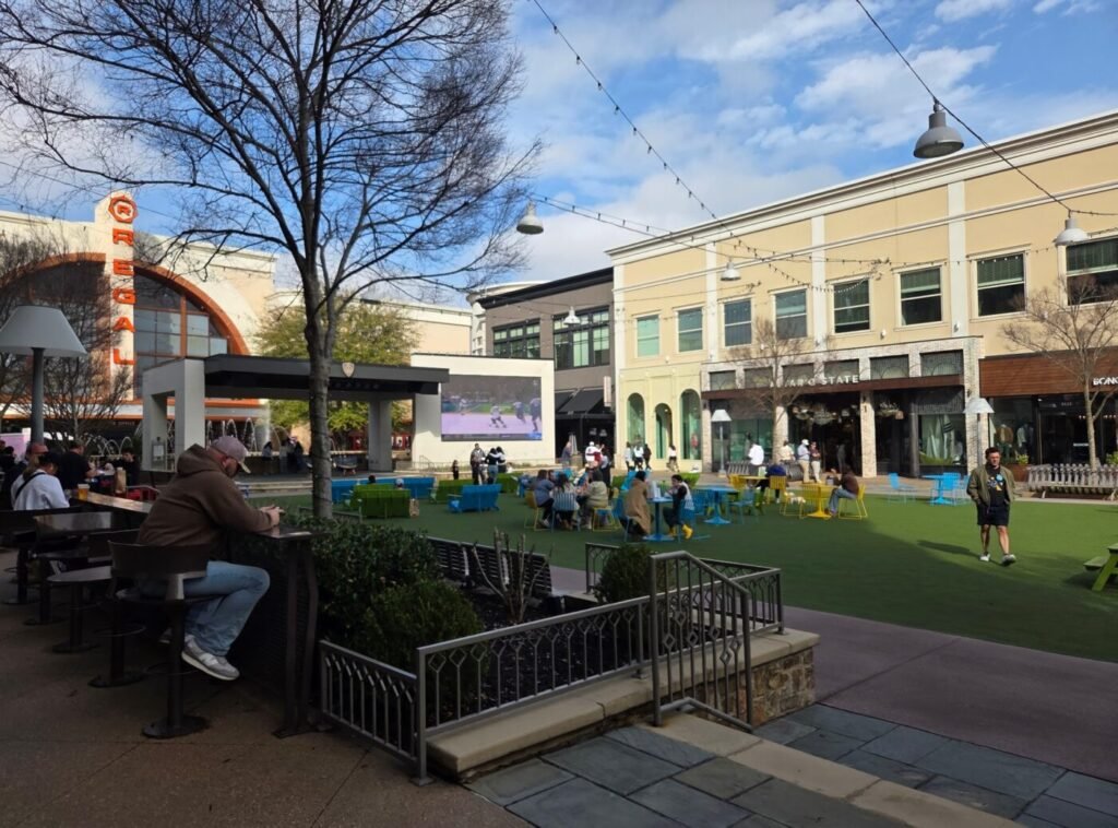 Avalon Alpharetta plaza with Regal cinema, outdoor seating area, and visitors gathering on the central green