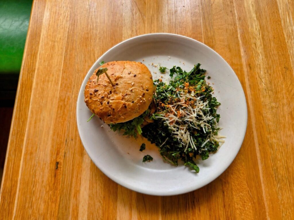 A simple, clean plate at True Food Kitchen in Avalon: a seeded burger paired with a fresh kale salad and shaved cheese