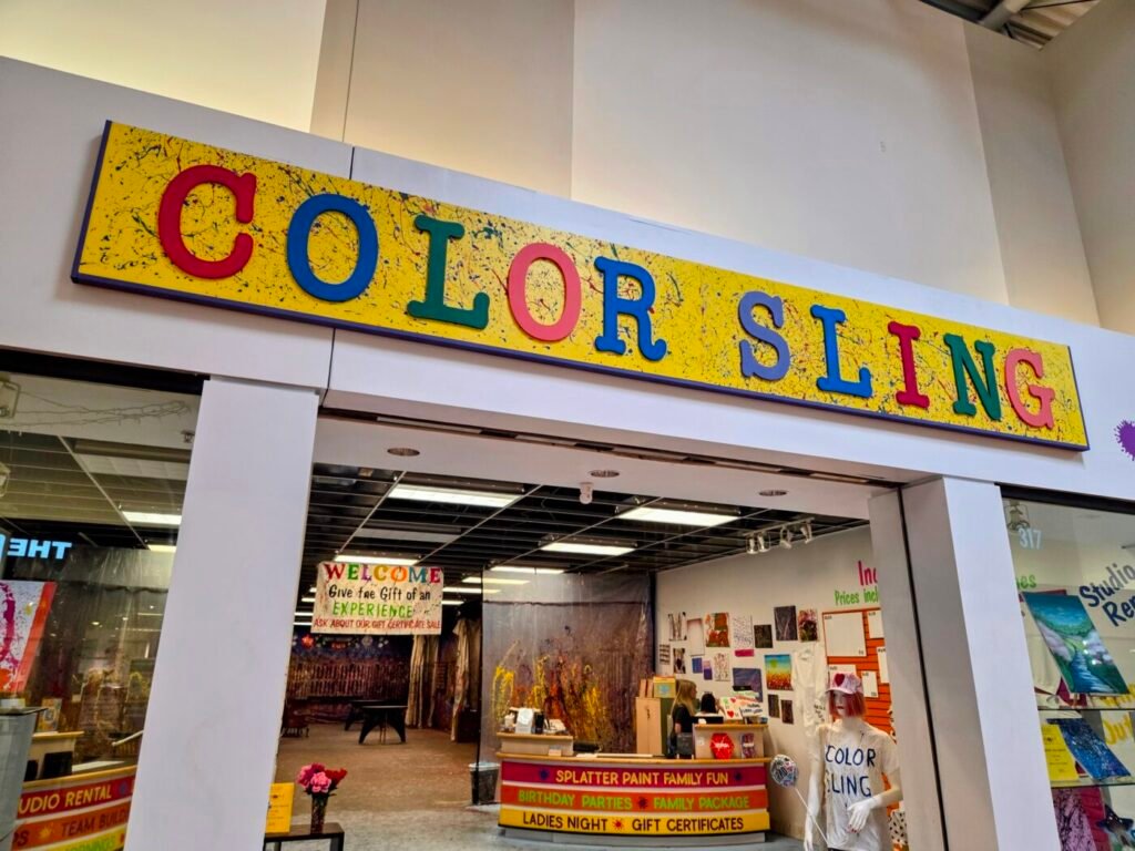 Color Sling splatter paint studio inside Sugarloaf Mills mall with colorful art displays and painting area