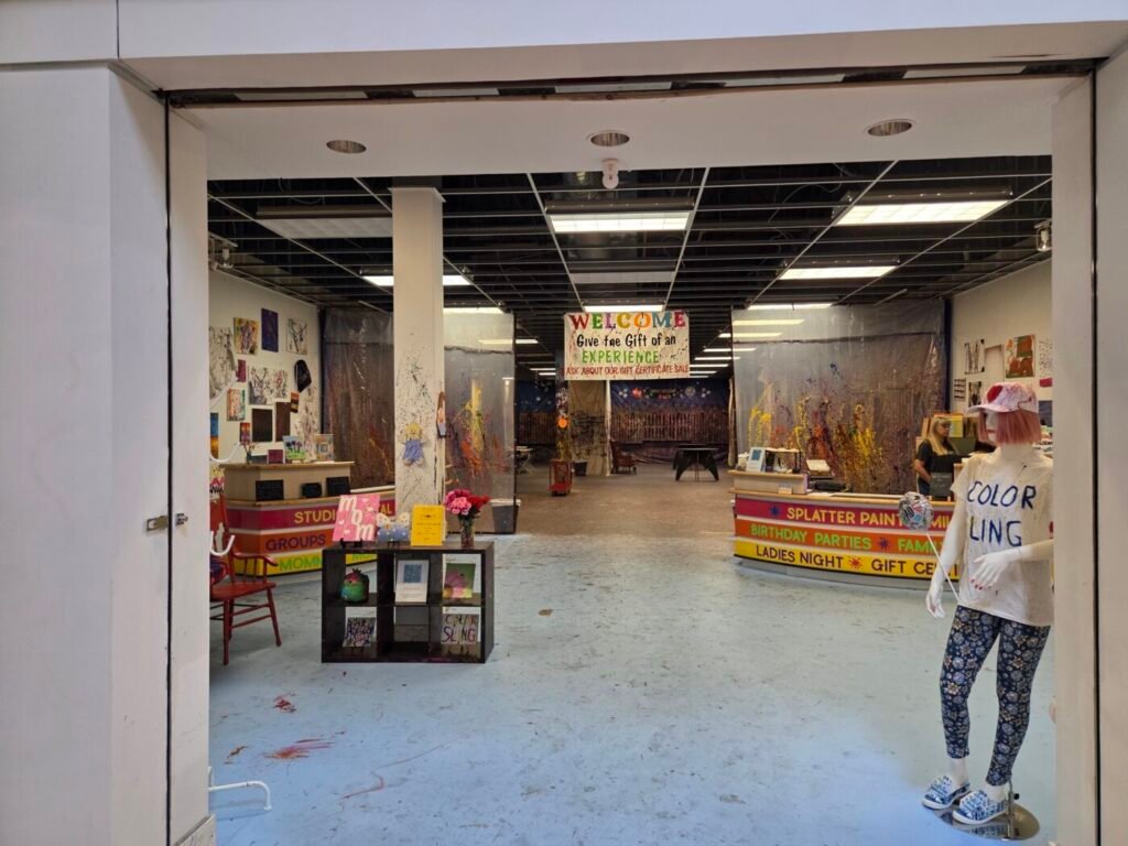 Color Sling splatter paint studio inside Sugarloaf Mills mall with colorful art displays and painting area