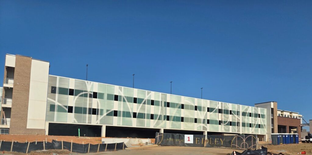 New structured parking deck under construction at Medley in Johns Creek, featuring modern facade panels and open levels