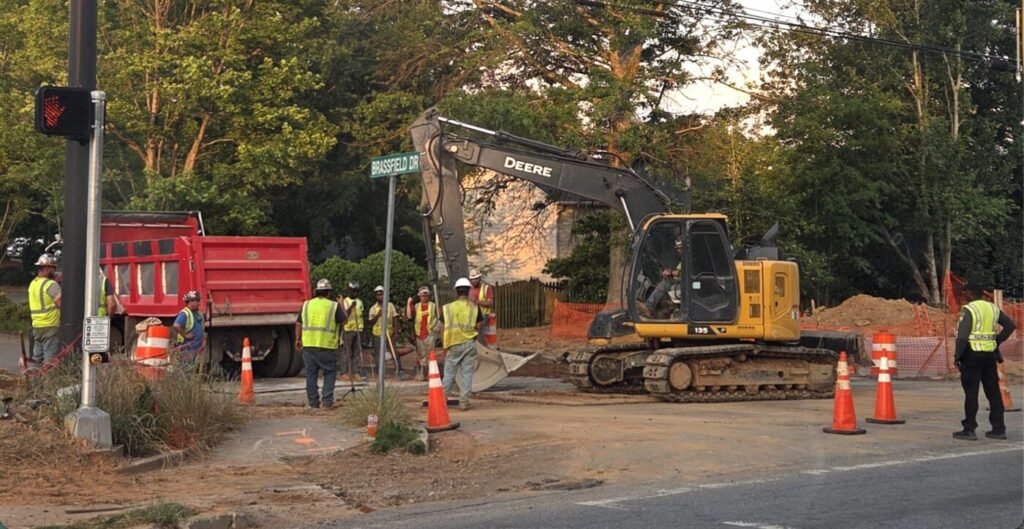 Construction crews and heavy equipment working at dusk near Brassfield Drive along McGinnis Ferry Road in Johns Creek