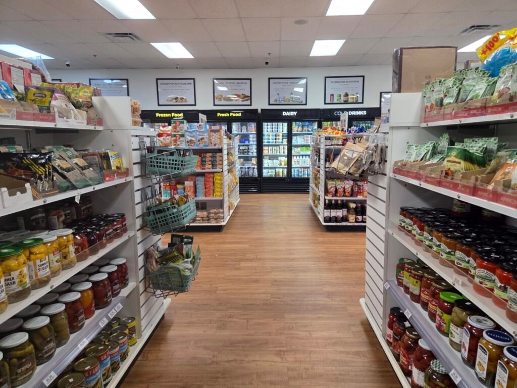 A clean aisle inside Golden Key European grocery store, with shelves of imported jars, pantry goods, frozen foods, dairy and cold drinks.