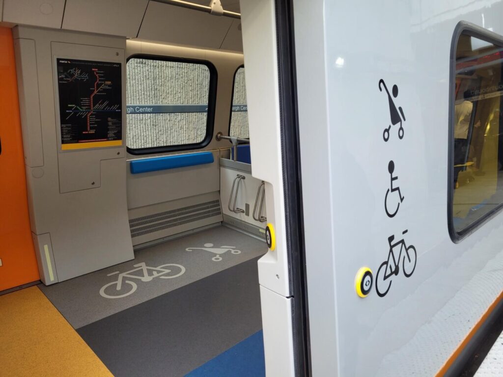 Interior of a new MARTA CQ400 train showing space marked for bicycles, strollers and wheelchair access.