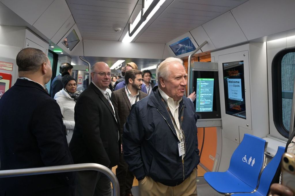 Officials and guests walk through the interior of a new MARTA CQ400 railcar during a preview event.