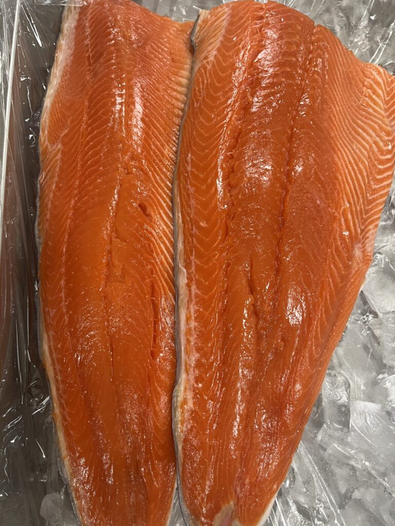 Bright orange fresh salmon fillets displayed on ice at Hook’d Up Seafood in Roswell.