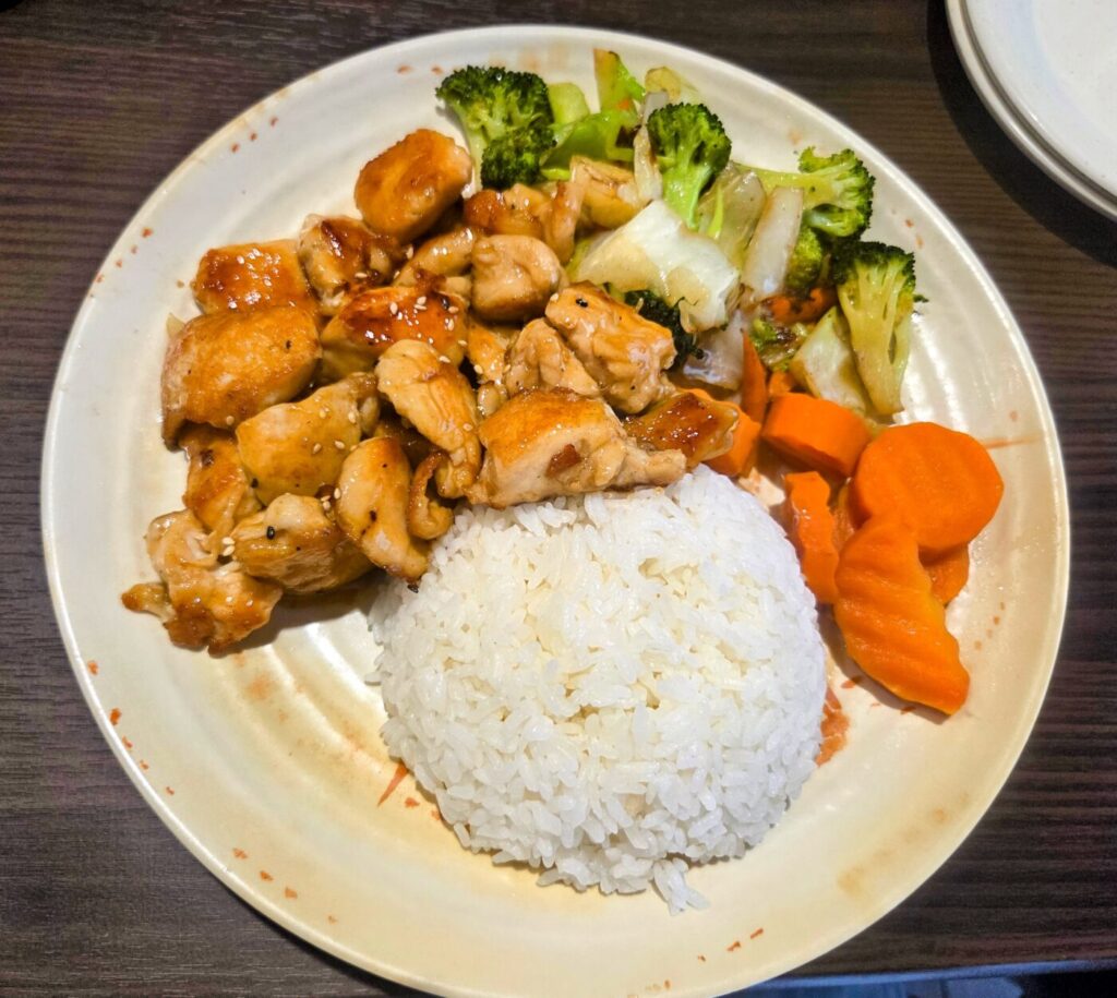 Hibachi chicken with white rice, sautéed vegetables and a glossy sauce.