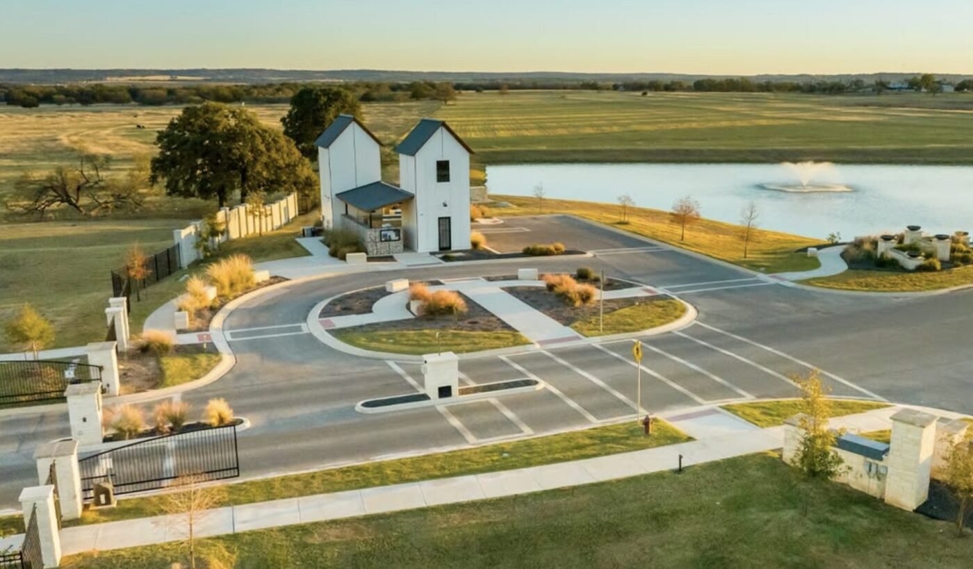Road intersection and circular drive beside a small white building near a lake