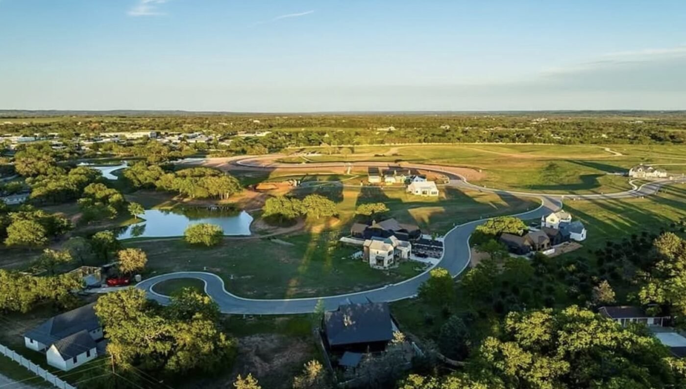 Aerial view of a new neighborhood with winding roads, homes, and scattered ponds