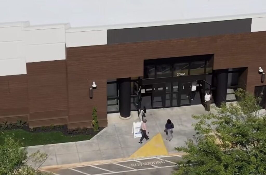 Exterior entrance of a brown commercial building with glass doors and a covered entryway