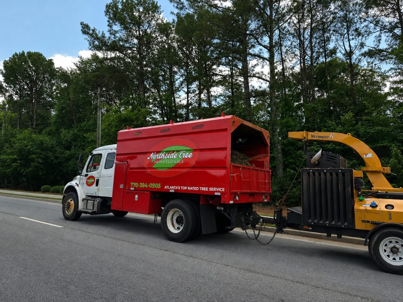 Tree crews work along a road as landowners across the South look for uses beyond traditional timber markets. A tree service truck and chipping equipment parked along a road