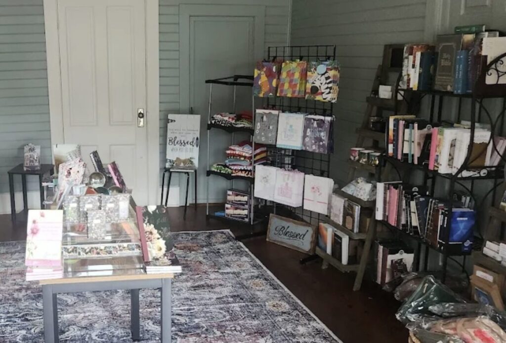 Books, journals and gift items arranged on shelves and tables inside a small shop