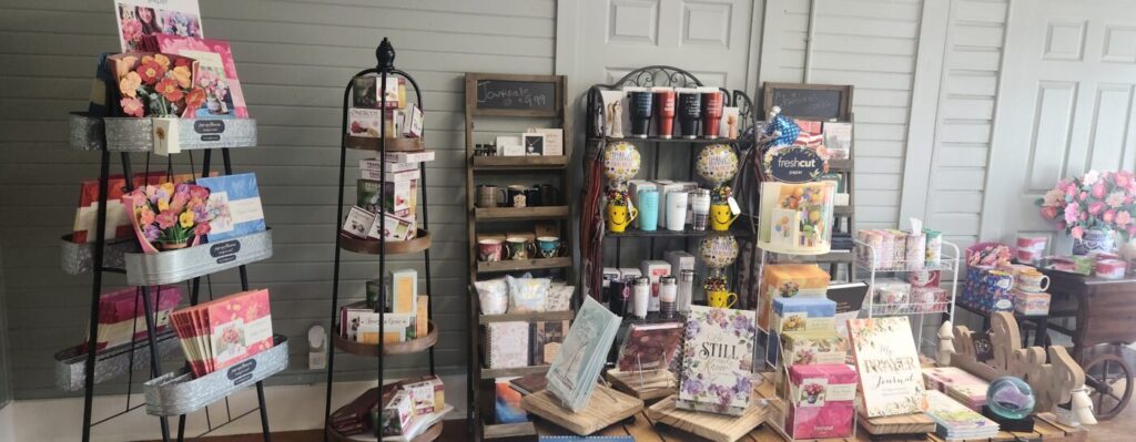 Display of gifts, mugs, cards and books arranged on shelves and tables