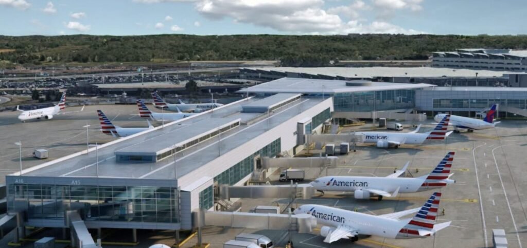 Airplanes parked at concourses outside a large airport terminal under a cloudy sky