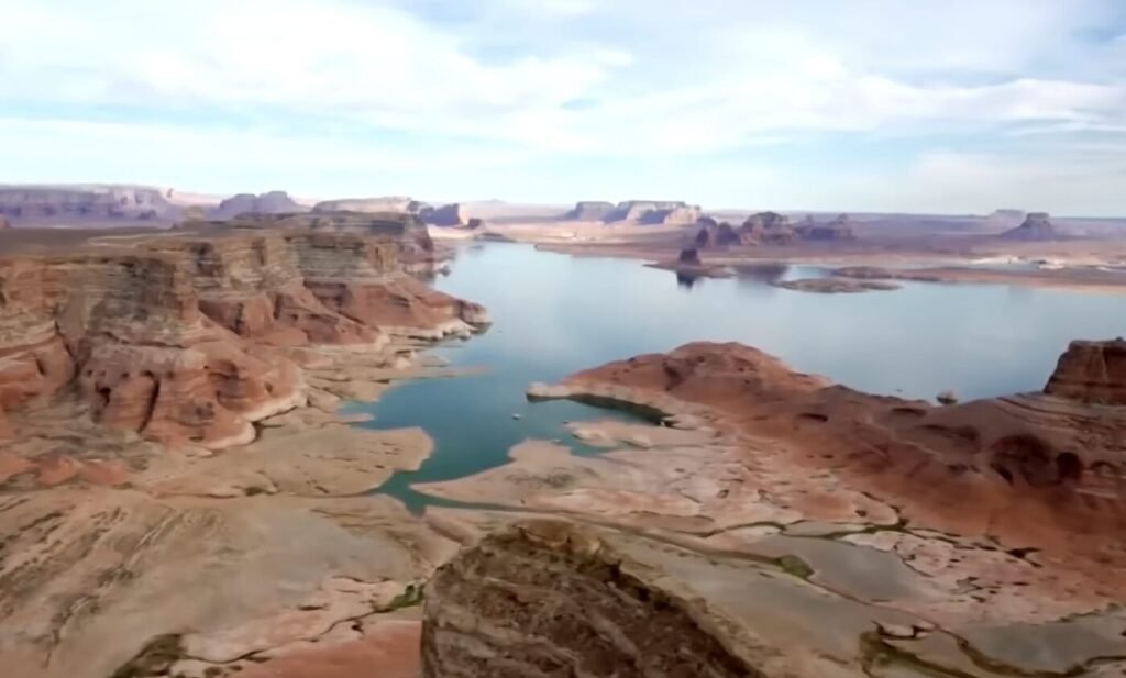 A wide reservoir stretches between rocky canyon walls and exposed shoreline.
