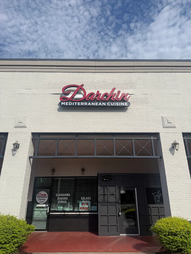 Fachada de la tienda con un letrero que dice Darchin Mediterranean Cuisine sobre la entrada.