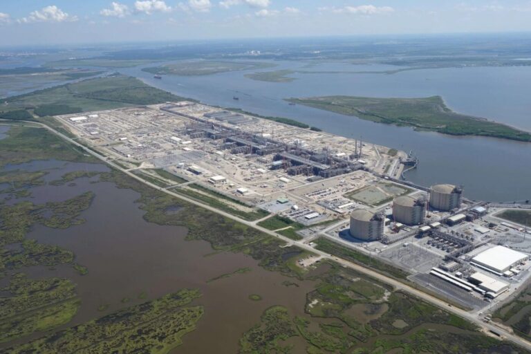 Aerial view of a large industrial complex beside waterways and marshland
