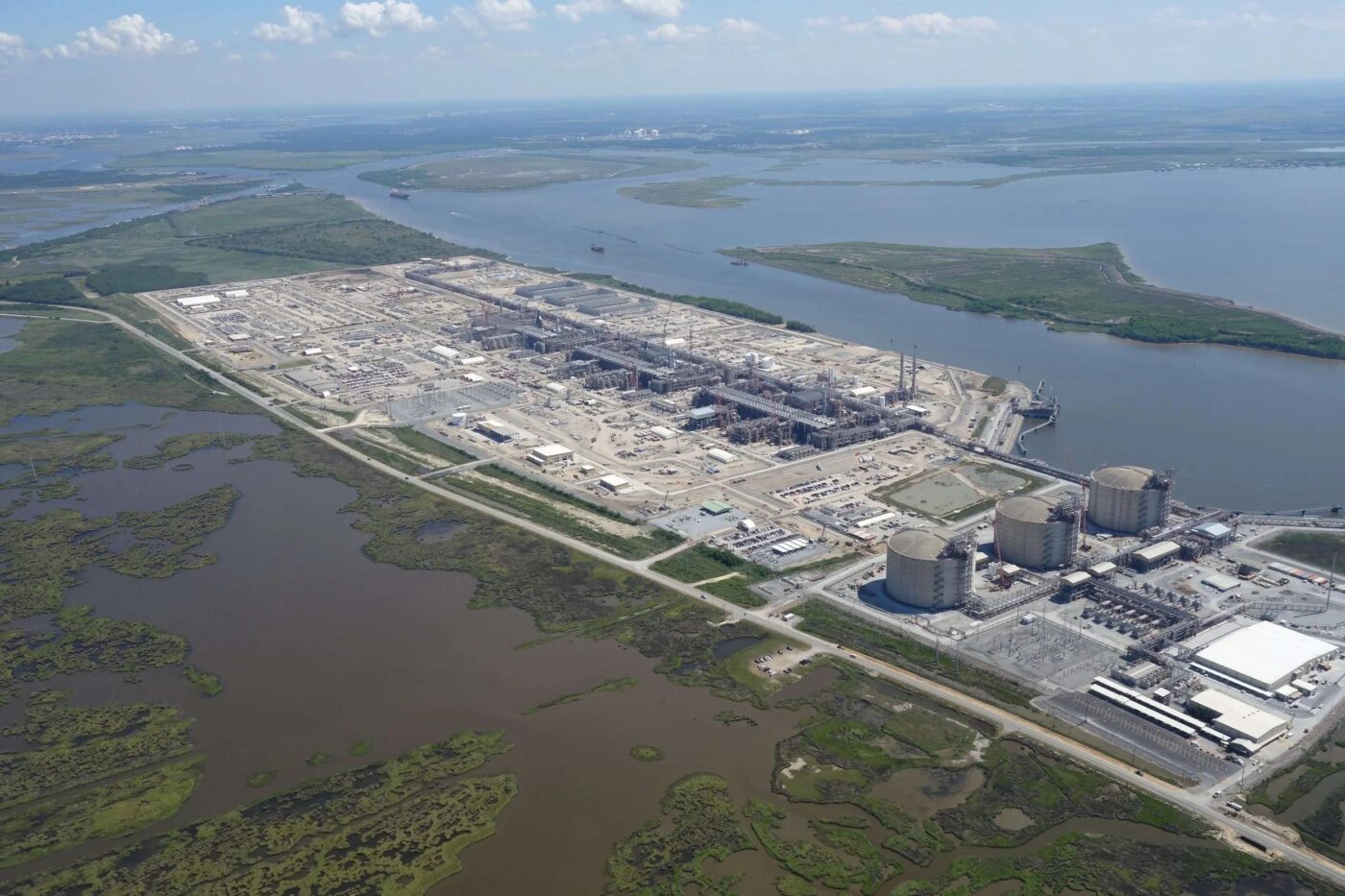 Aerial view of a large industrial complex beside waterways and marshland
