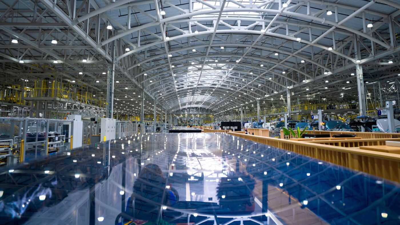 Vista amplia del piso de la fábrica en Hyundai Motor Group Metaplant America con una carrocería de vehículo brillante en primer plano.