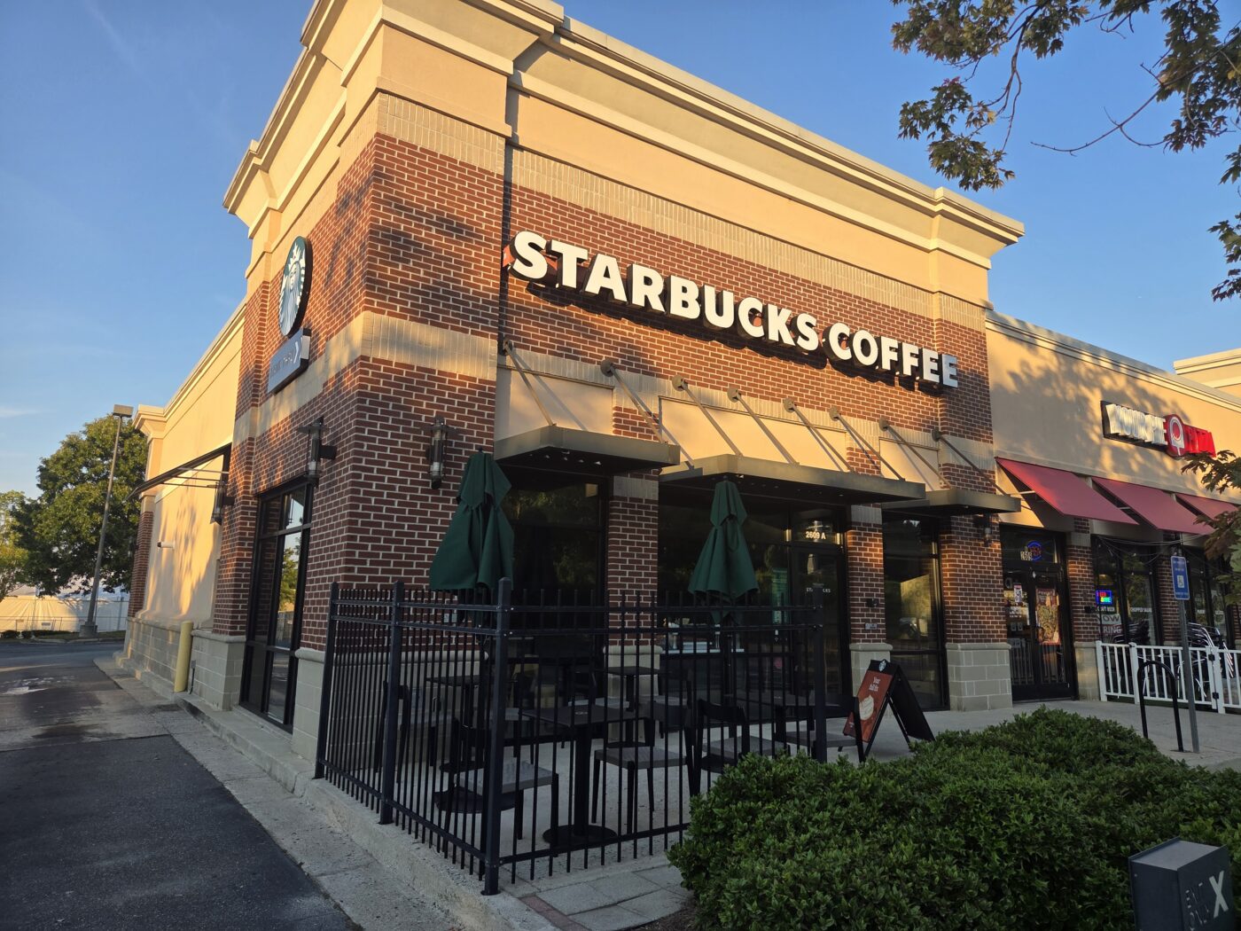 Starbucks Coffee storefront in a brick shopping center at sunset