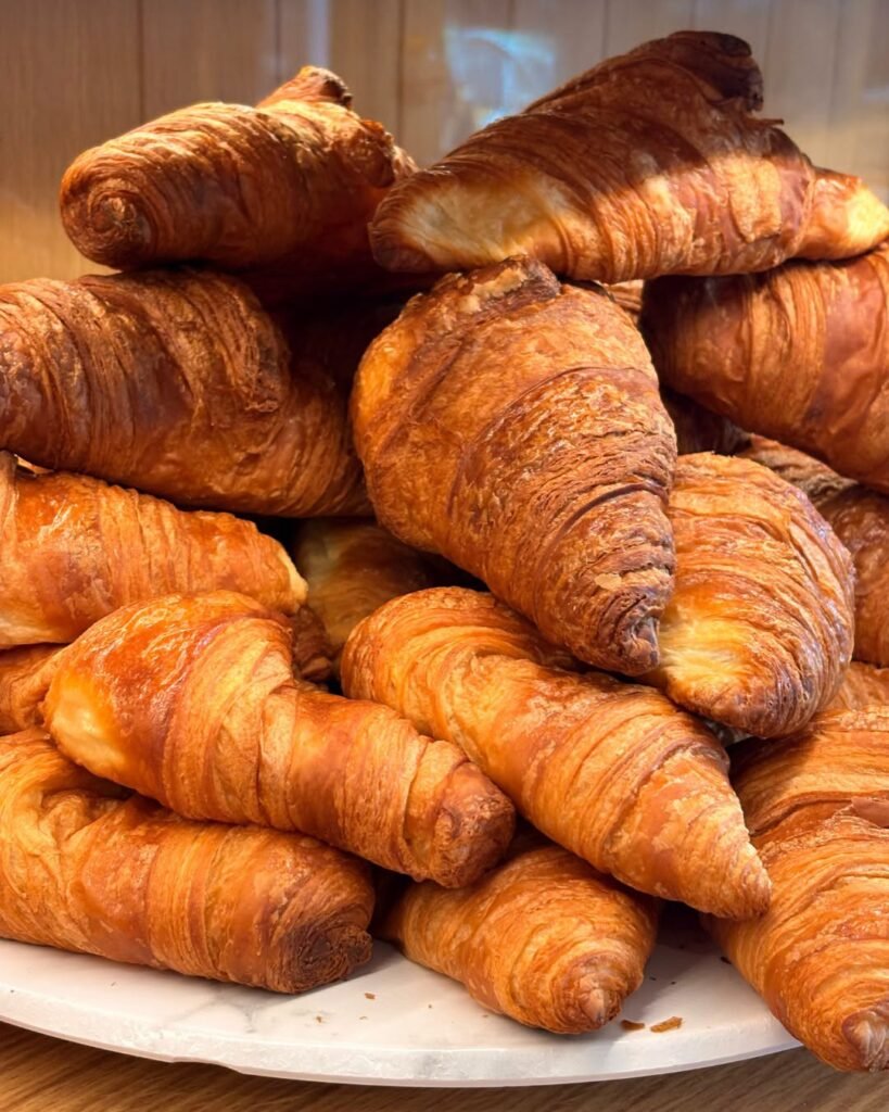 Stack of plain croissants on a white plate