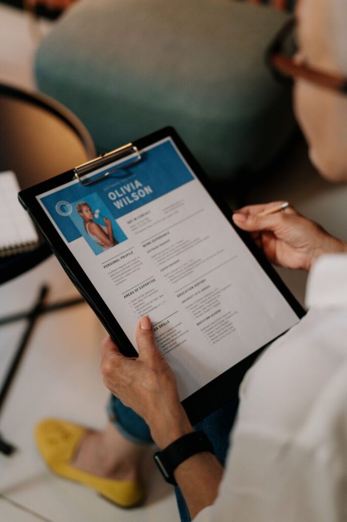 Hands holding a clipboard with a resume during a consultation