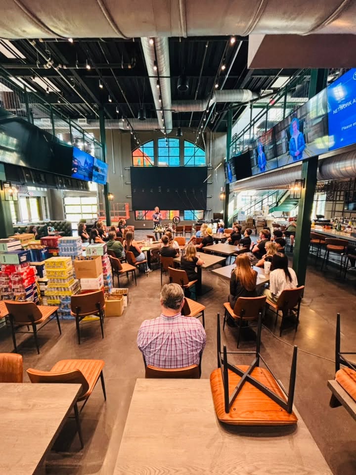 People seated in a restaurant dining room with televisions mounted overhead