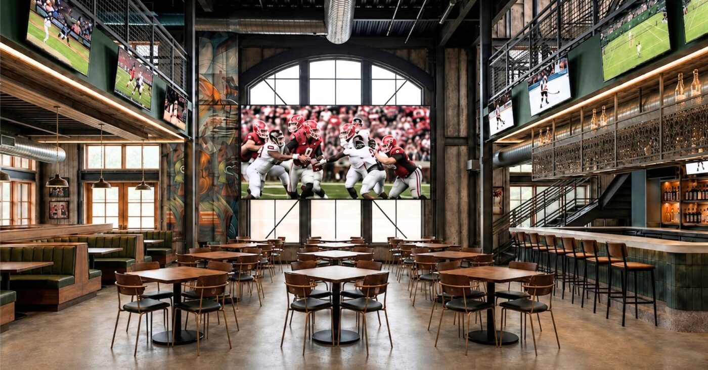 Empty dining room with tables, booths and multiple televisions showing football games
