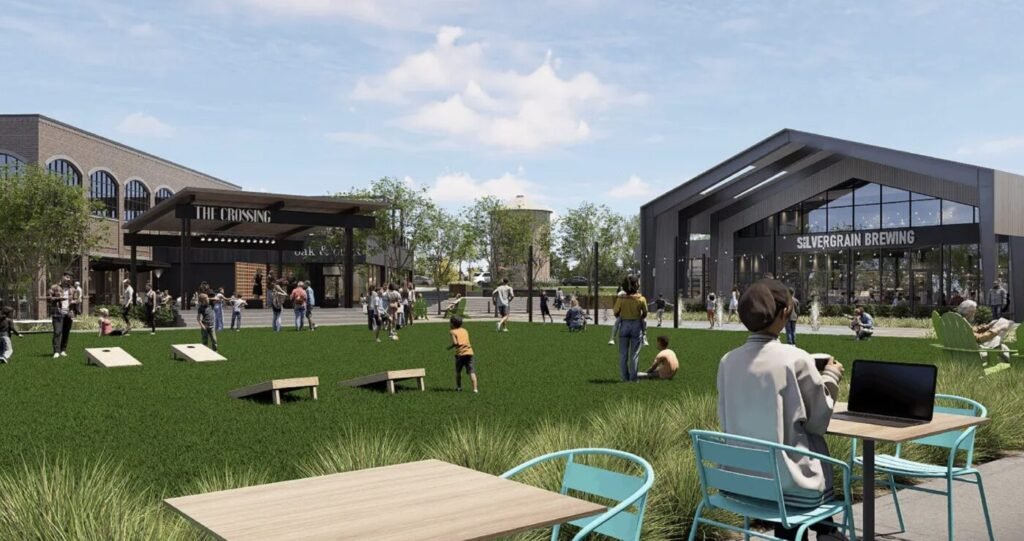 A digital rendering of a village green with people seated outdoors near commercial buildings.