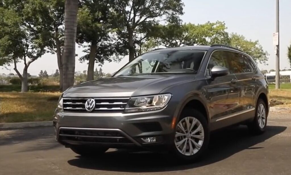 Gray Volkswagen Tiguan SUV parked on a paved road with trees in the background.