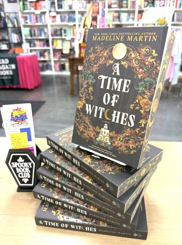 A display of stacked books featuring a copy of A Time of Witches in a bookstore.