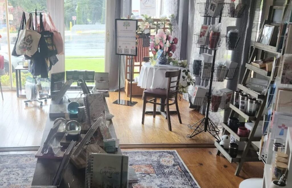 Interior of a small shop with books, gift items, a display table and a windowed front room