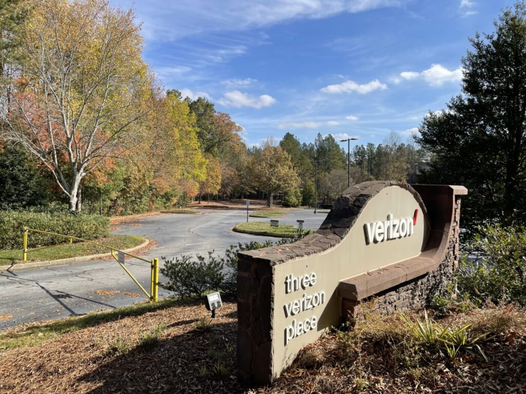 Verizon campus entrance sign beside a curved driveway and trees