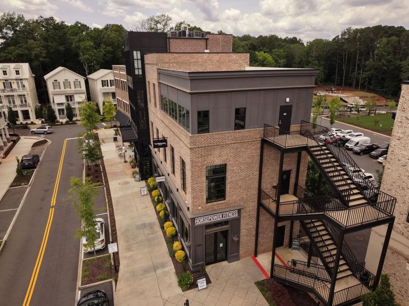 Elevated view of brick commercial buildings and neighboring homes at Adair Park in Woodstock.