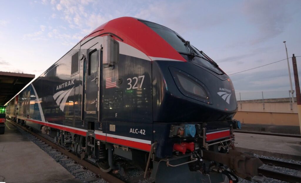 Amtrak locomotive No. 327 beside a station platform.