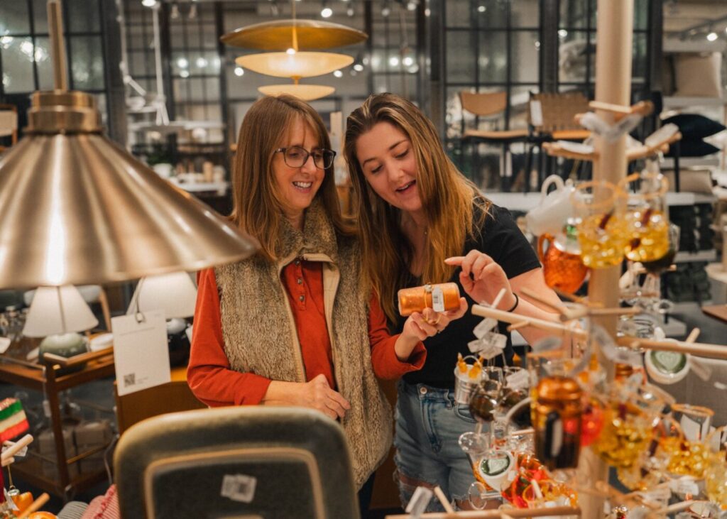 Two shoppers browse holiday merchandise inside a store at Avalon.