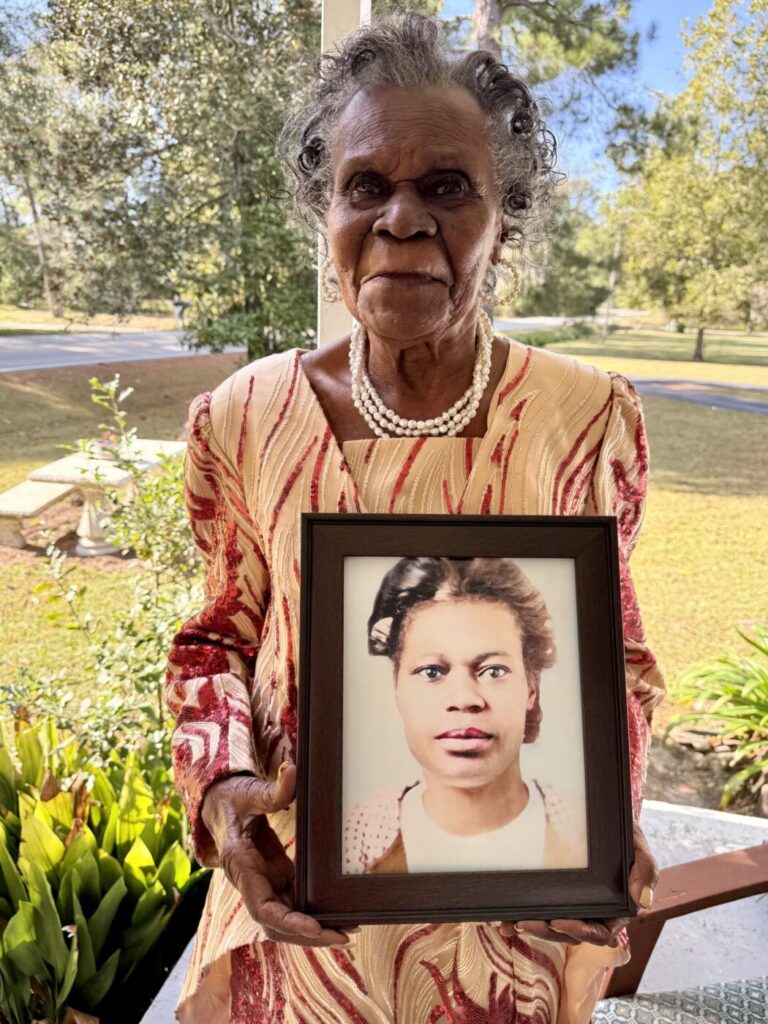 Clara Britt holds a framed photograph of herself as a young woman.