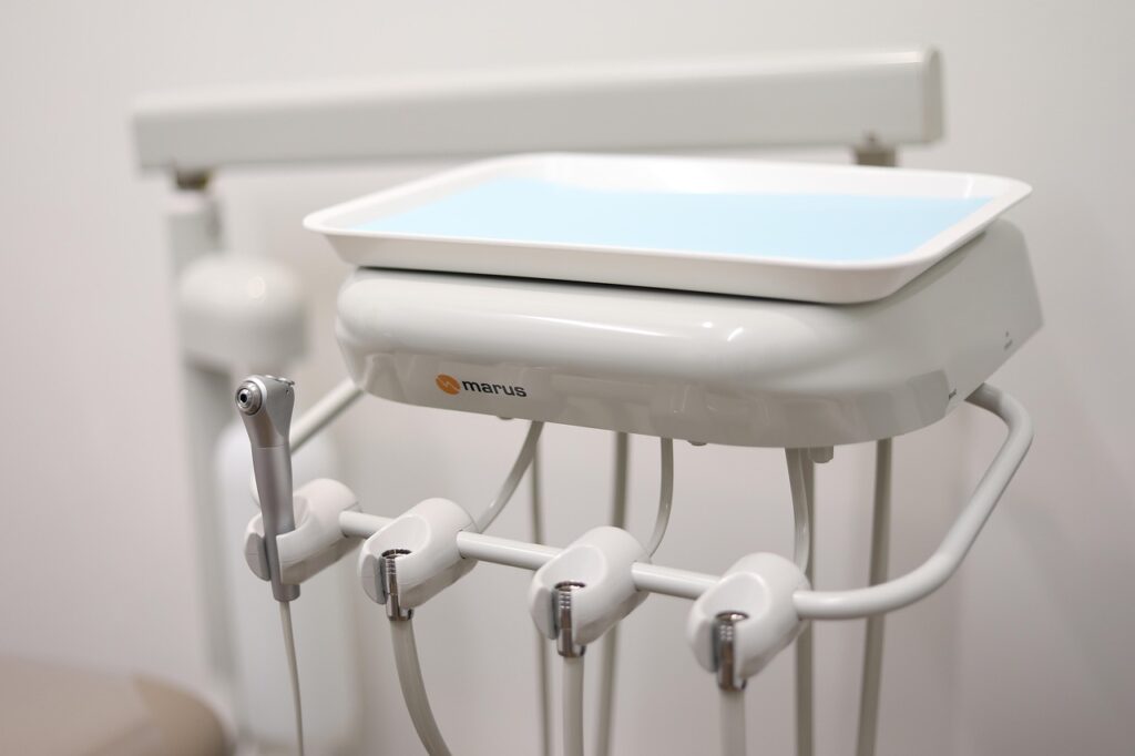 Dental chairside tray and handpieces in a treatment room.
