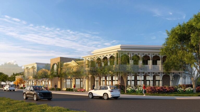 A rendering of two-story storefront buildings with balconies, trees and cars along a street at dusk.