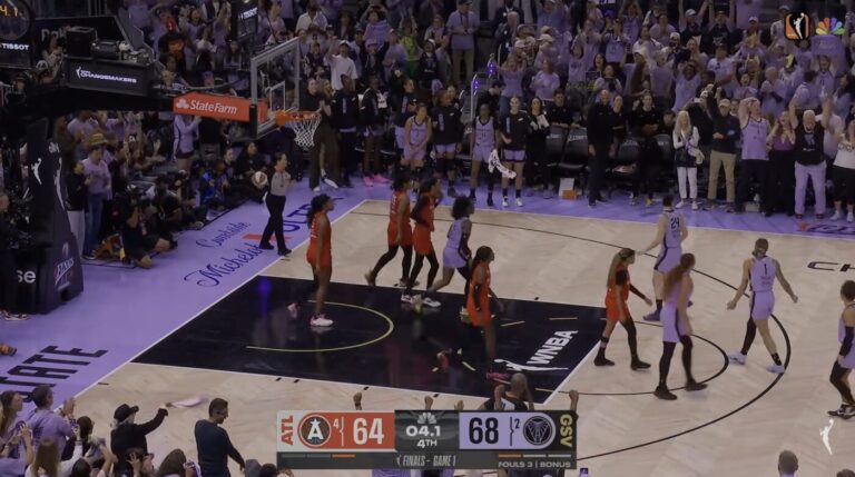 Jugadoras de baloncesto y oficiales se congregan cerca de la canasta mientras el marcador muestra a Golden State liderando 68-64 sobre Atlanta en el último cuarto.