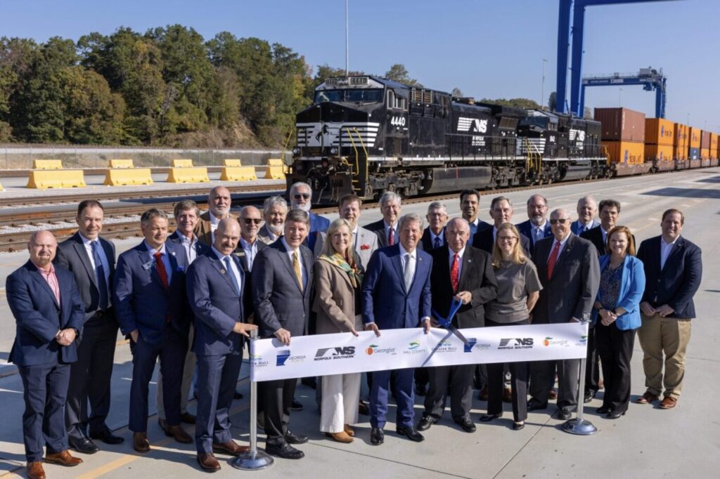 Gov. Brian Kemp and officials cut a ribbon in front of a Norfolk Southern train at Gainesville Inland Port.