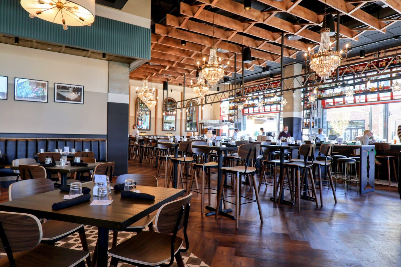 Dining room with chandeliers, exposed wooden beams and bar seating