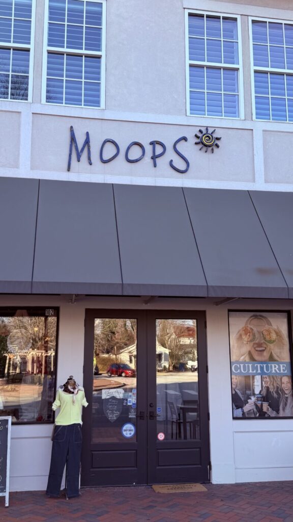 The Moop's storefront with double doors, display windows and the boutique name on the facade.