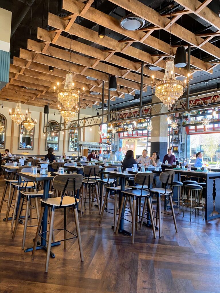Guests seated under chandeliers in a bright dining room