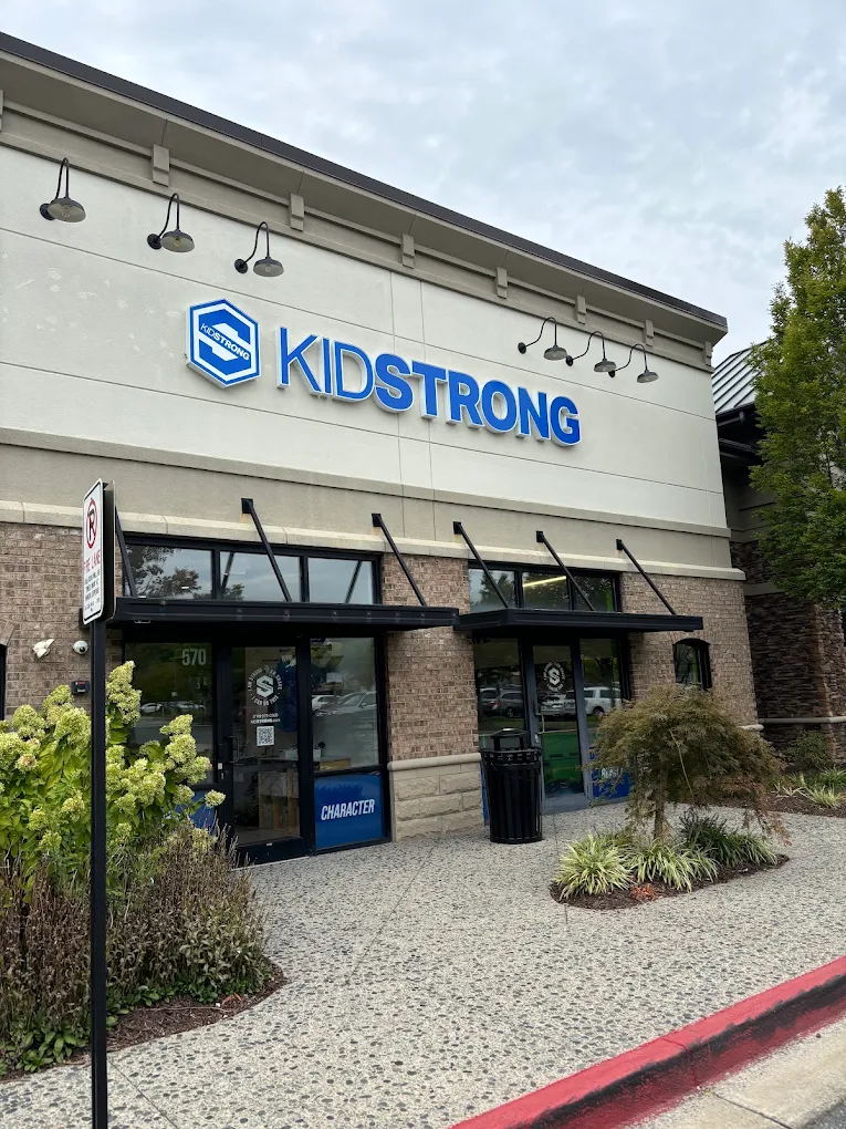 KidStrong storefront with blue sign above the entrance and a glass doorway beneath an awning