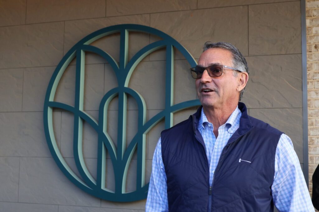 Mark Toro standing beside Medley’s emblem during the tour.